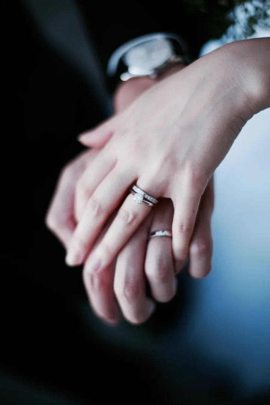 A close photograph of two hands and a ring