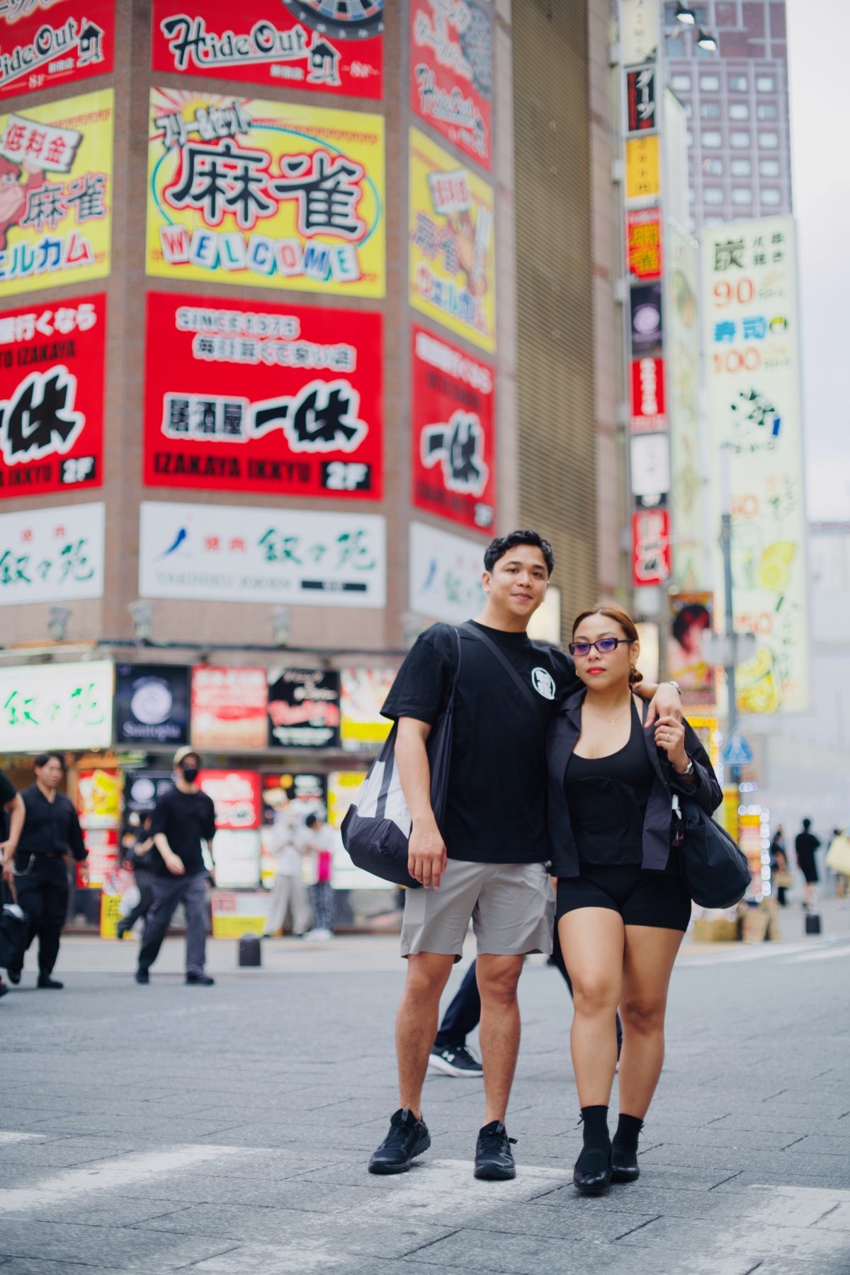 A couple standing in the middle of a Kabukicho street