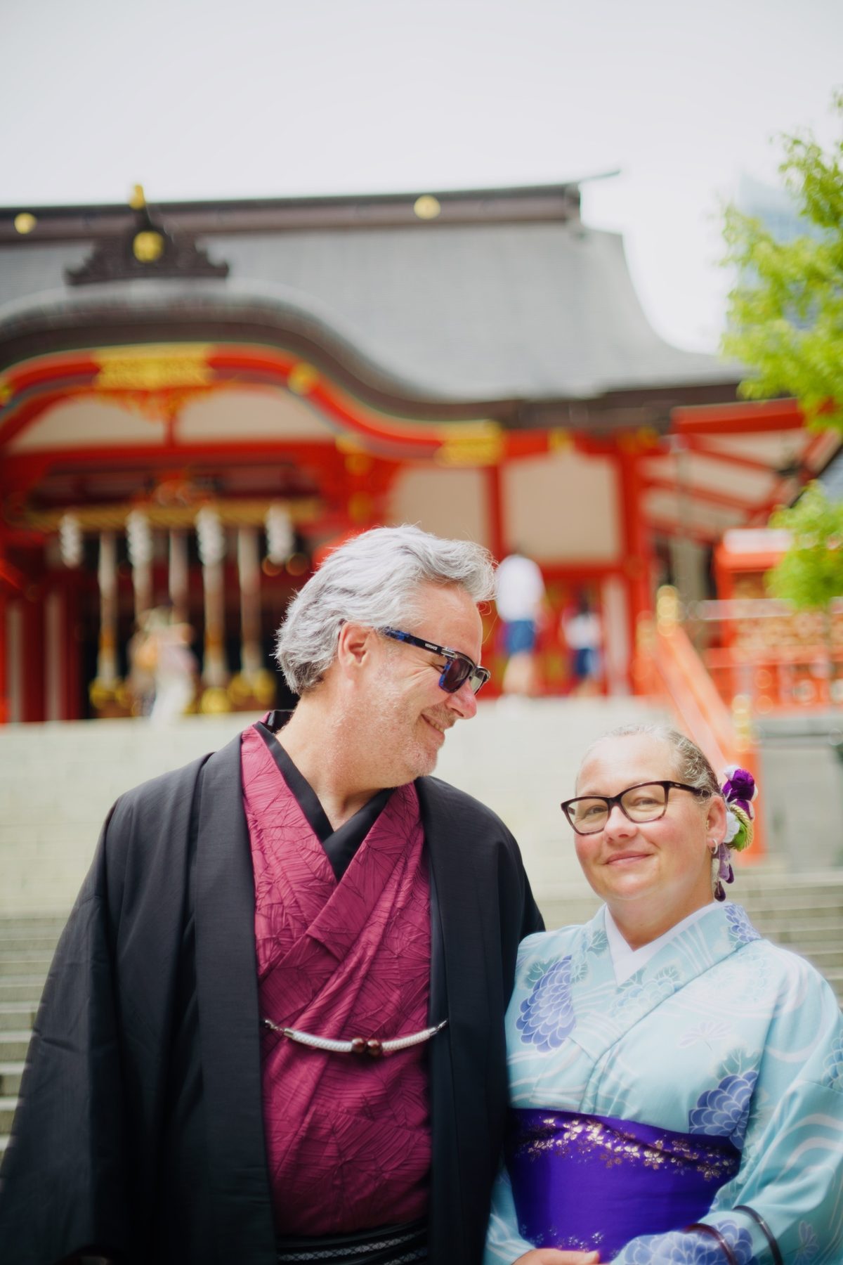 A couple in kimono, photographed close, at a shrine