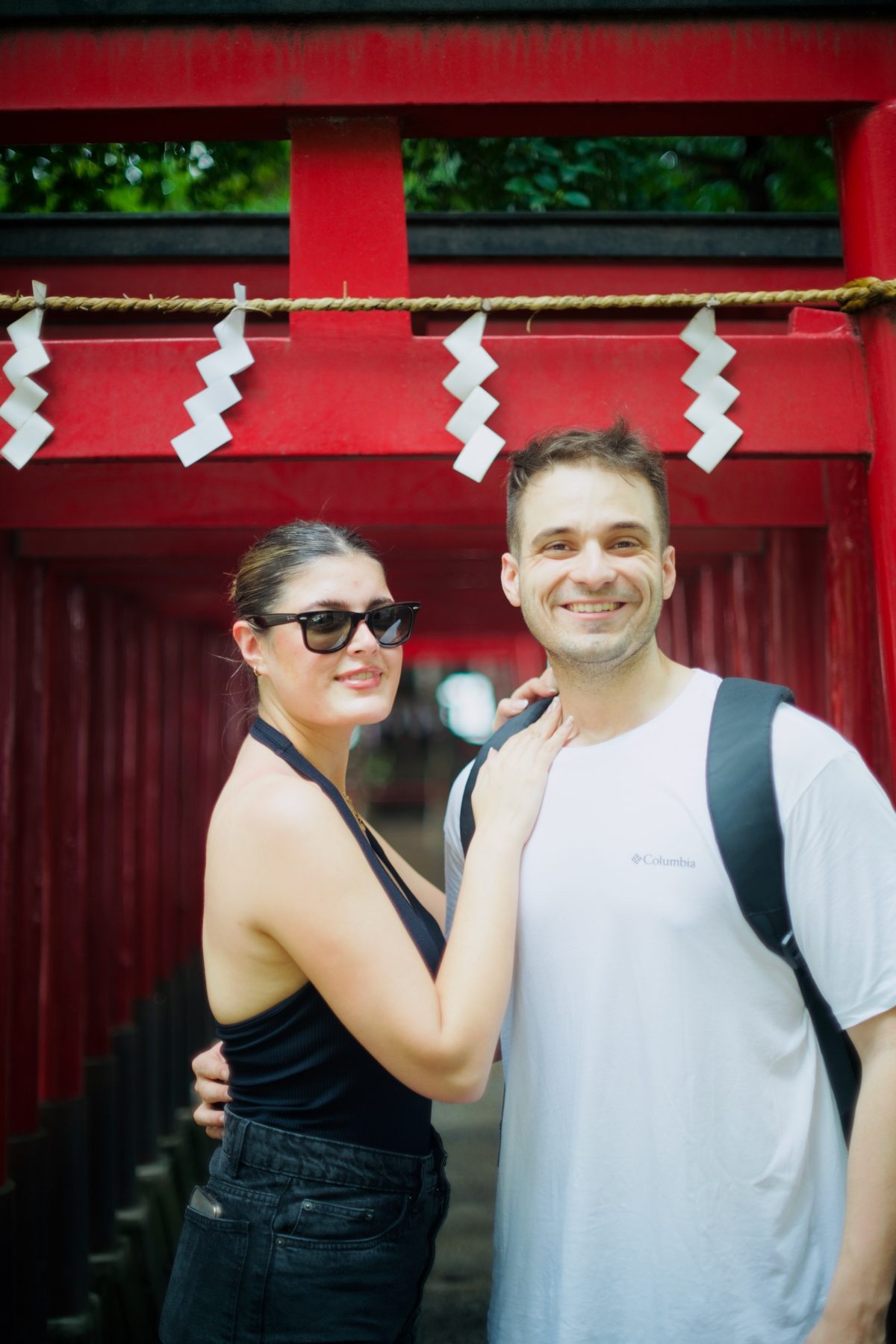 A couple beneath a red torii gate