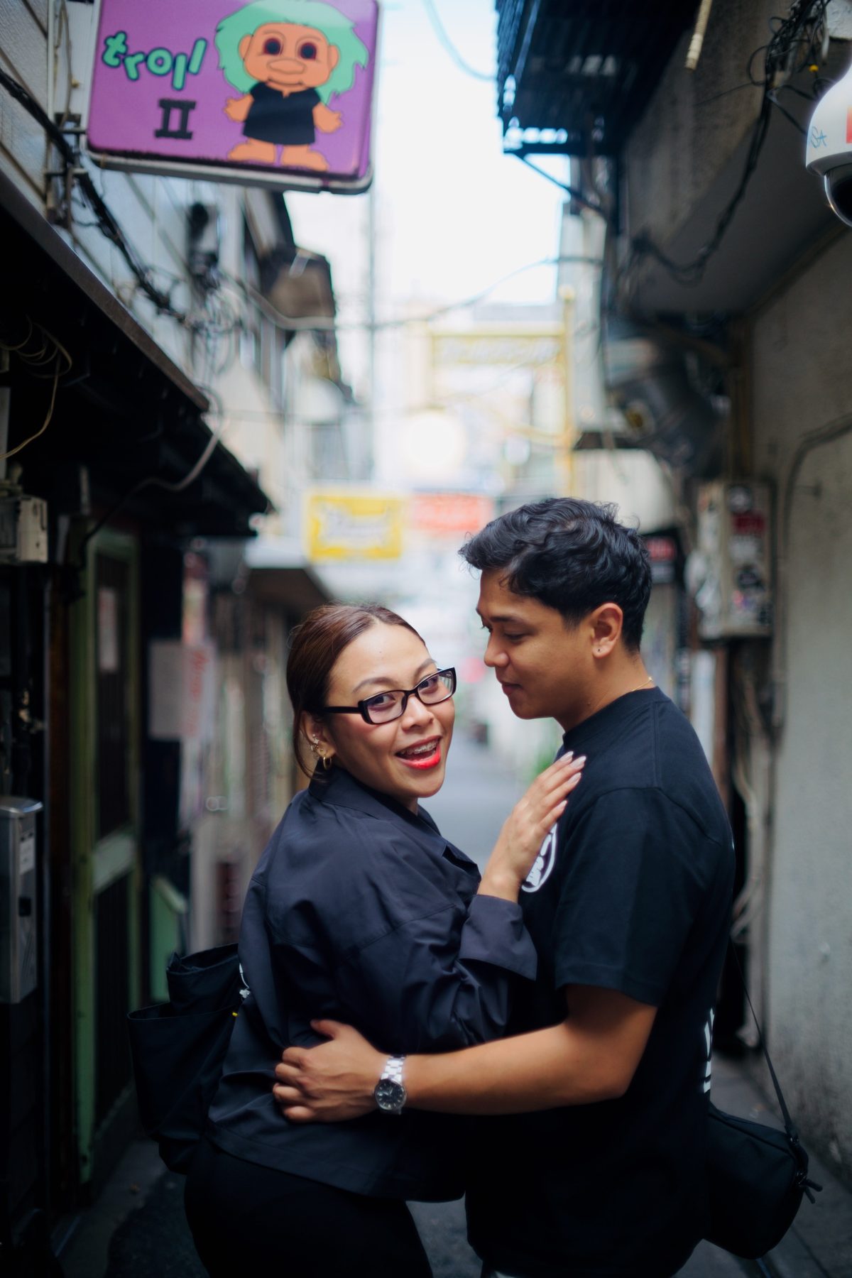 A couple laughing together under a shop sign